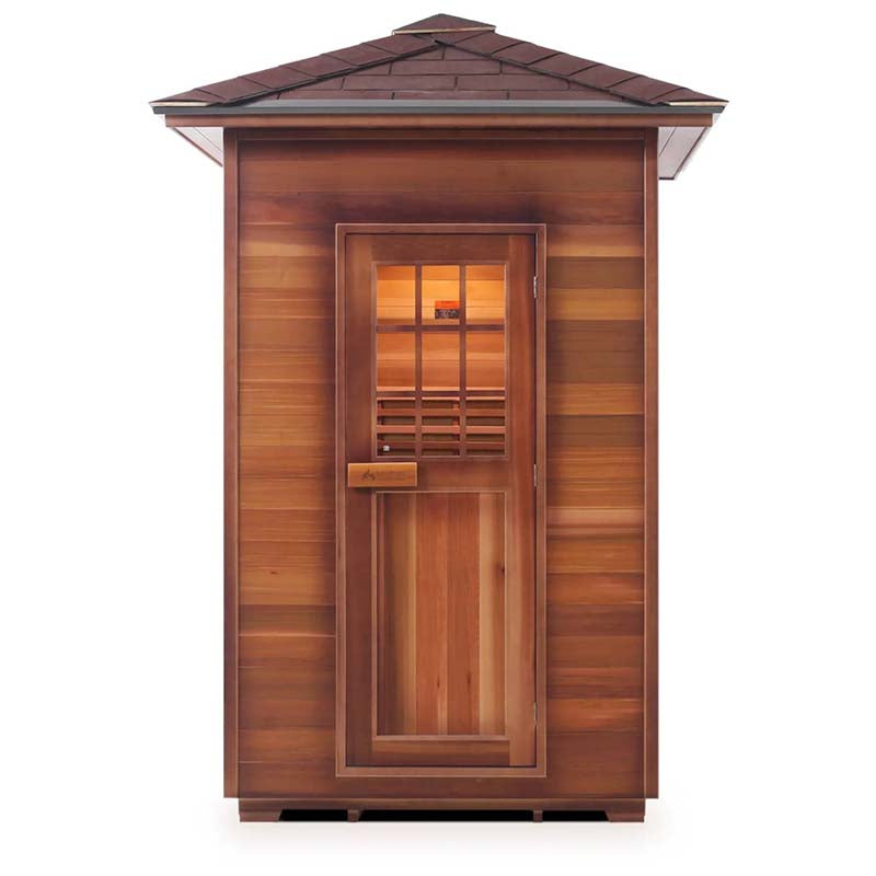 Cedar infrared sauna cabin with windowed door and slanted shingled roof.