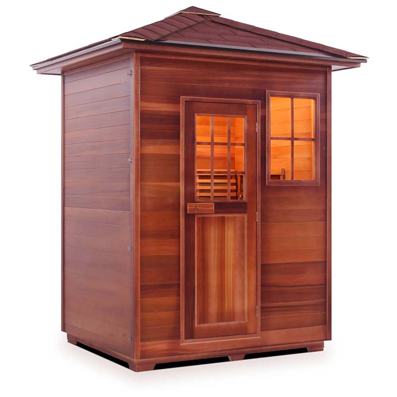 Red cedar outdoor sauna with glass paneled door and window, illuminated interior.