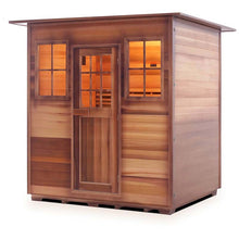 Outdoor cedar sauna with glass windows and warm interior lighting.