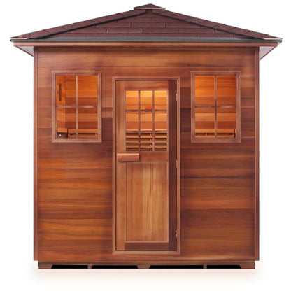 Cedar barrel sauna with windows and a shingled roof, ideal for outdoor relaxation.