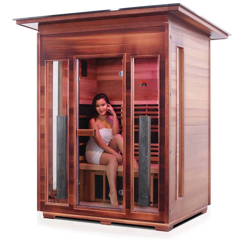 Woman relaxing in a cedar infrared sauna with glass doors.