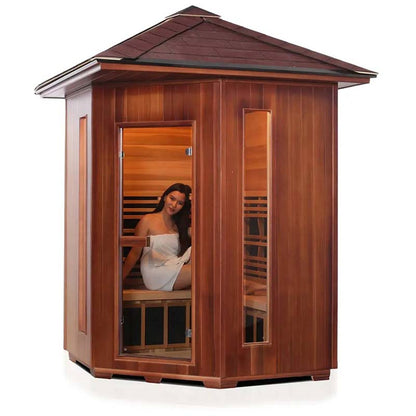 Woman relaxing in a wooden infrared sauna with glass door and modern design.