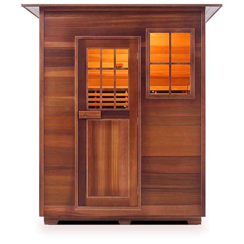 Cedar infrared sauna cabin with glass door and window, warm interior lighting.