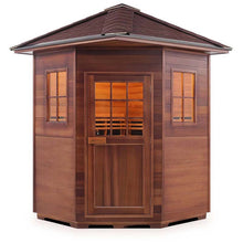 Outdoor cedar sauna with shingled roof and windowed door for relaxation.