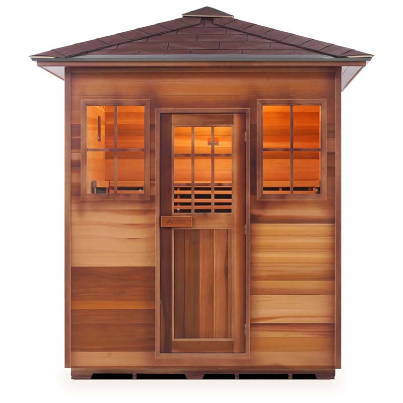 Outdoor cedar sauna with a shingled roof, featuring warm interior lighting.