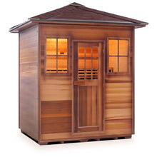 Outdoor cedar sauna with shingled roof and illuminated windows for home relaxation.
