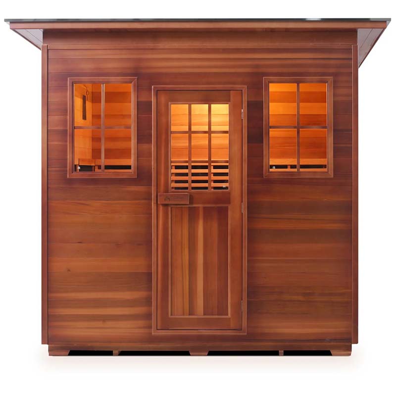 Outdoor cedar sauna with glass windows and door, warm interior lighting.