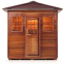 Outdoor cedar sauna with shingled roof and three windows, ideal for relaxation.