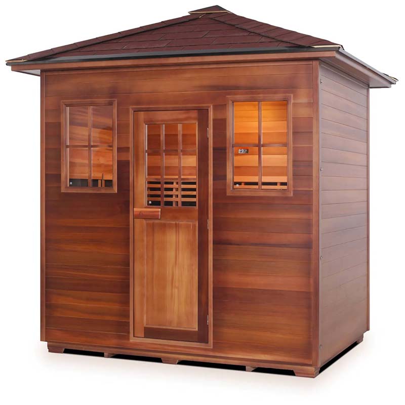Cedar sauna with shingled roof and illuminated interior.