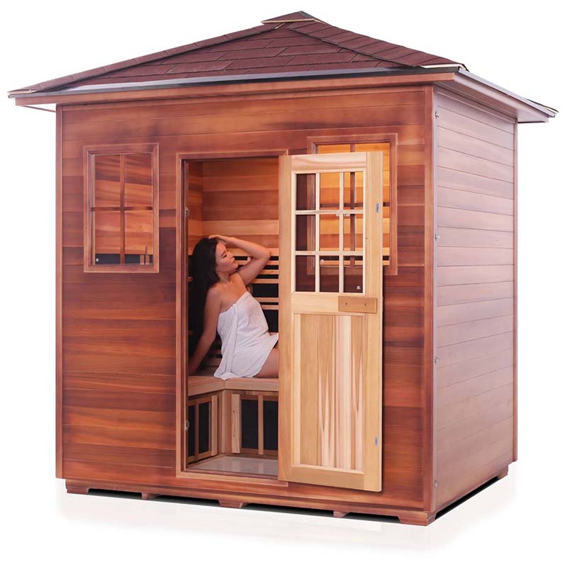 Wooden sauna with open door, featuring a woman relaxing inside on a wooden bench.