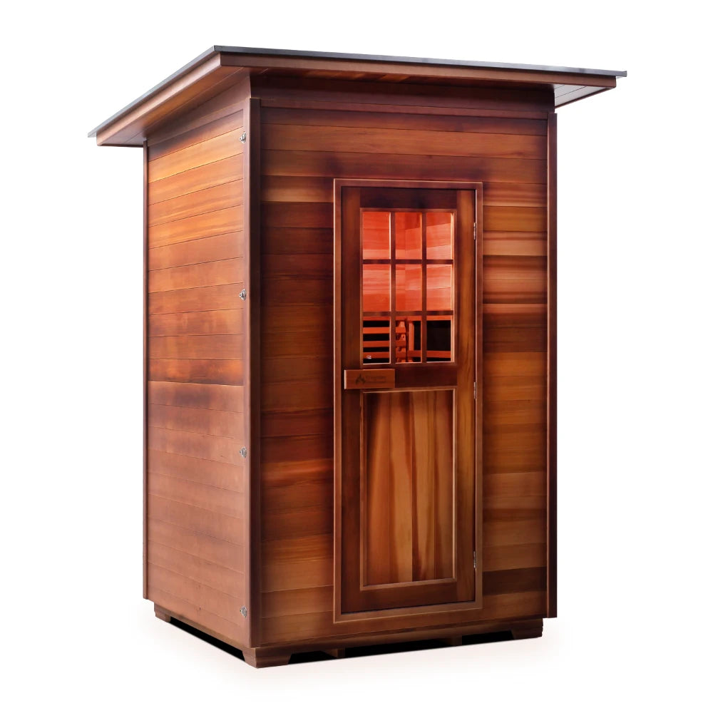 A wooden sauna cabin with a slanted roof, featuring a door with multiple windows, showcasing its natural wood finish and design.