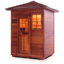 Cedar wood sauna with warm interior lighting and a shingled roof.