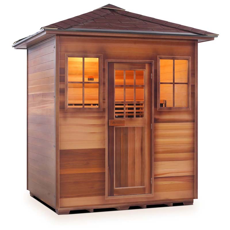 Outdoor cedar sauna with warm interior lighting and shingled roof.