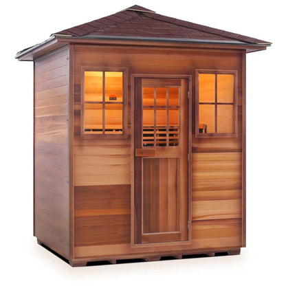 Outdoor cedar sauna with warm interior lighting and shingled roof.