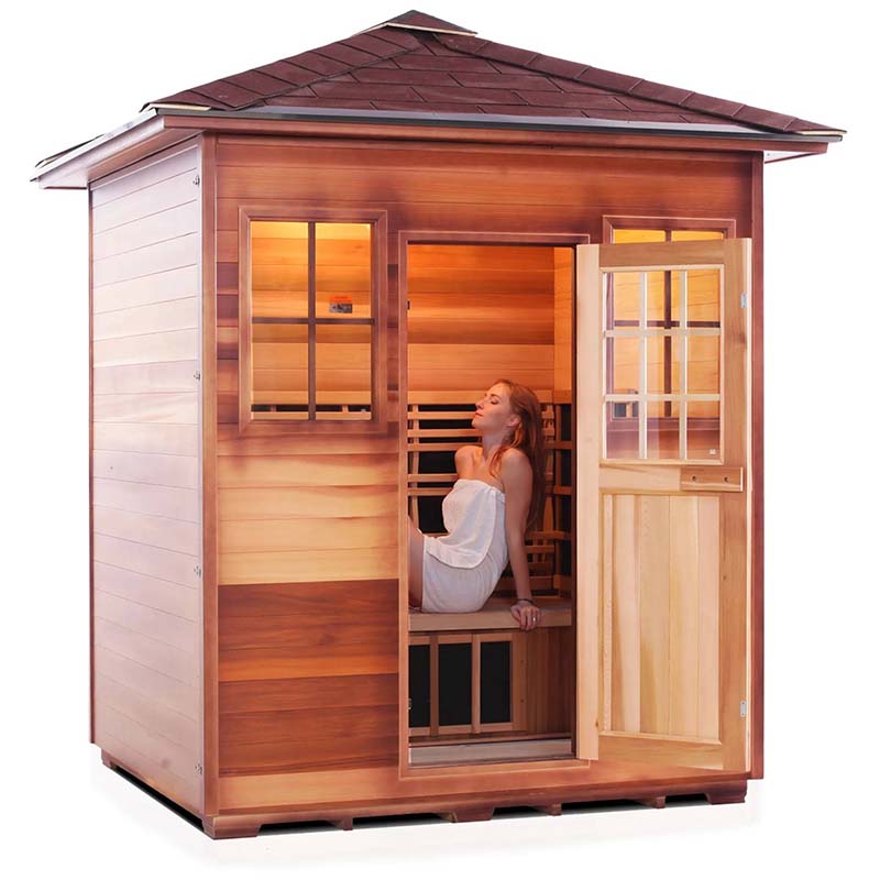 Outdoor cedar sauna with a woman relaxing inside, showcasing its wooden design and spacious interior.