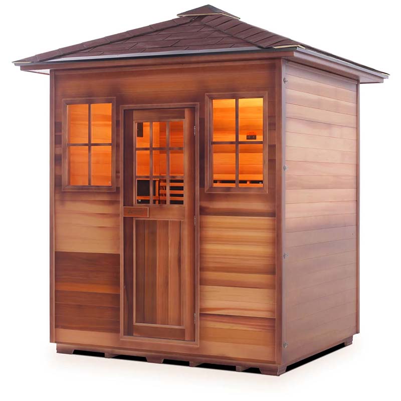 Outdoor cedar sauna with warm interior lighting and shingled roof.
