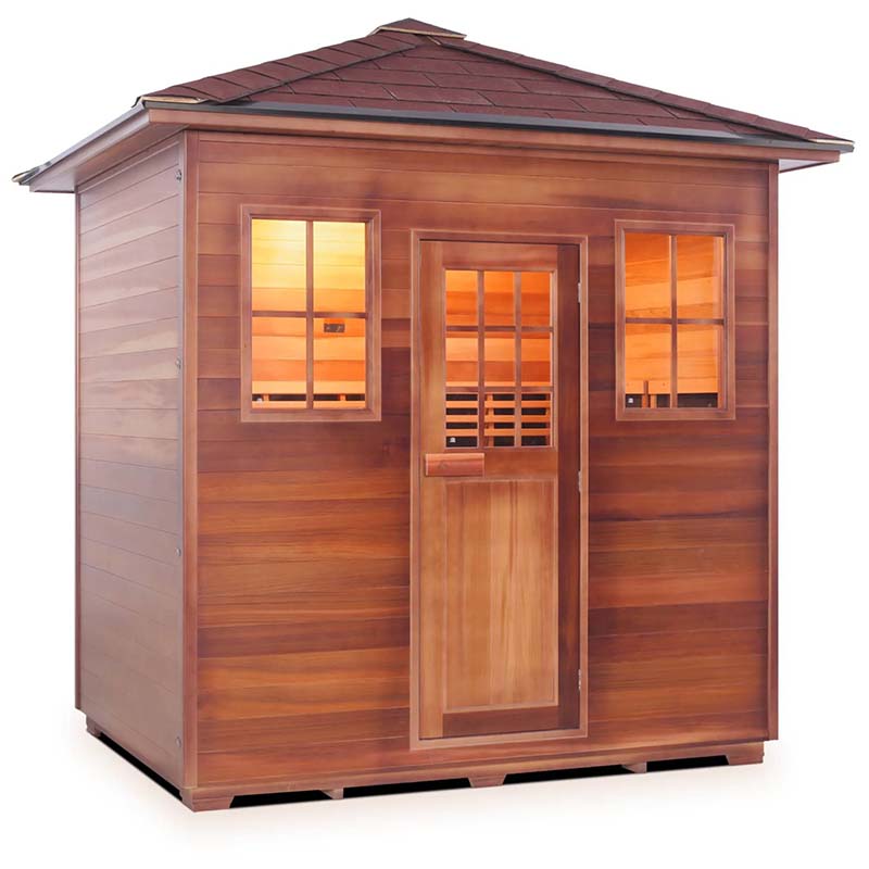 Cedar sauna with glass door and windows, warm interior lighting.