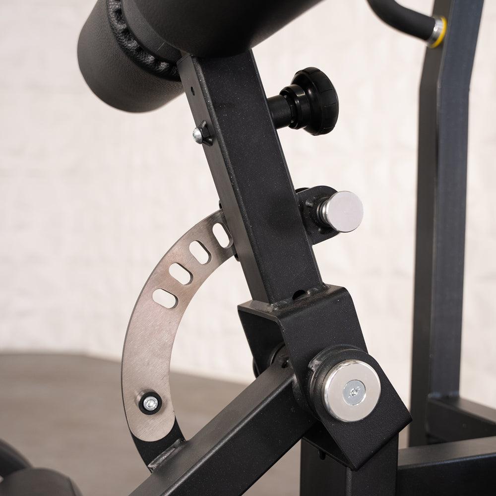 Back extension machine with padded roller and adjustable metal frame.