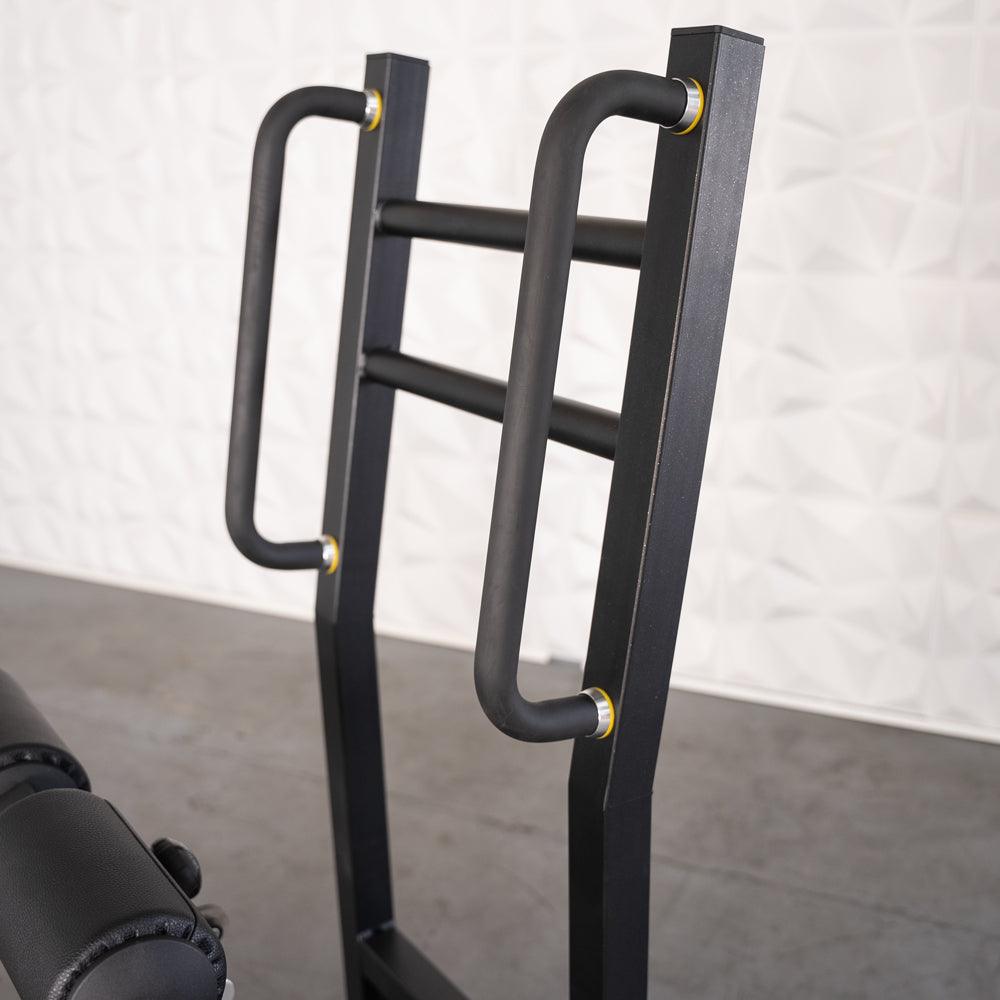 Back extension gym machine with black padded handles and frame.
