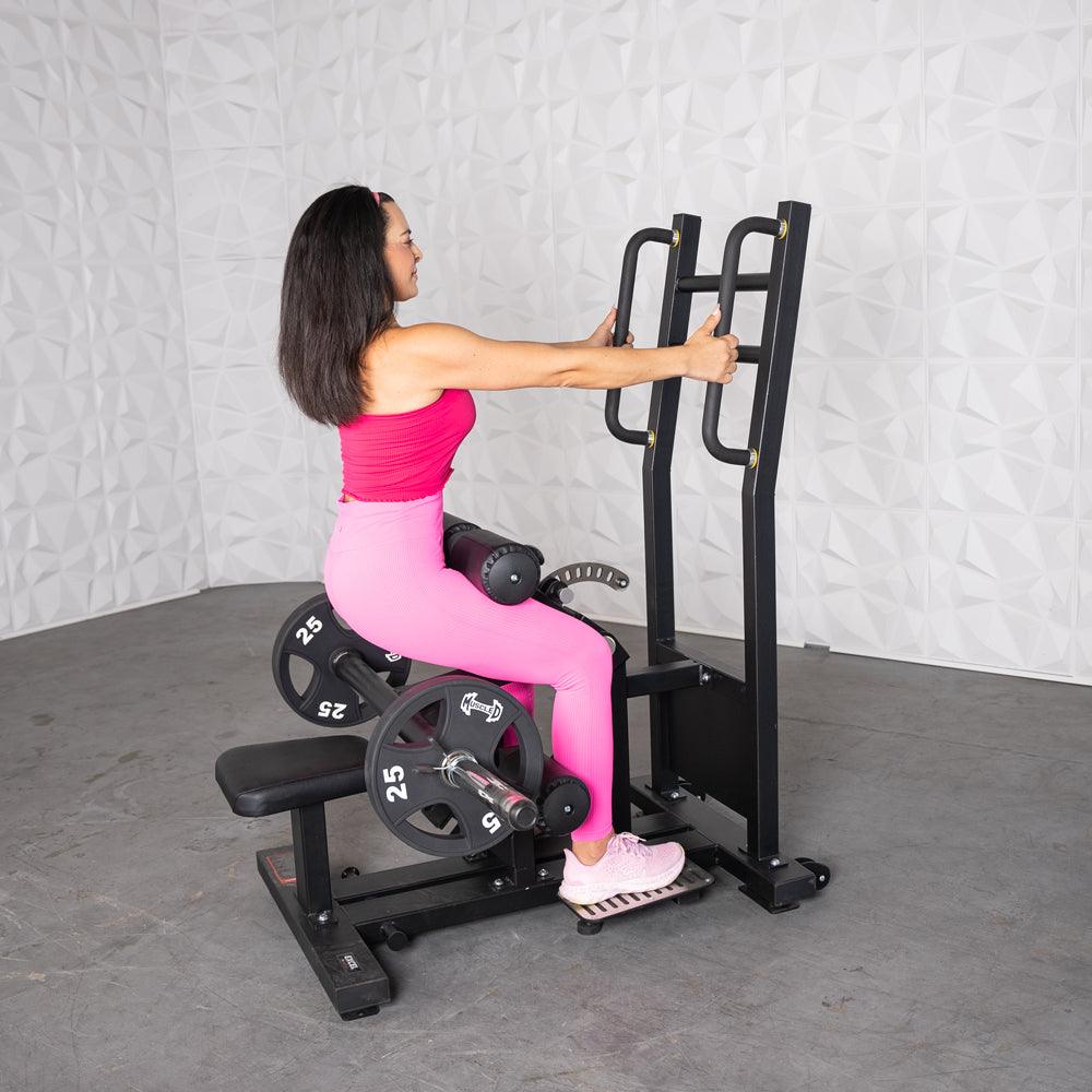 Woman in pink athletic wear using a back-extension gym machine.