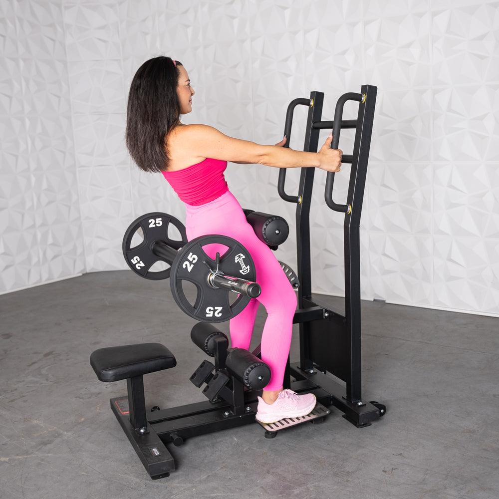 Woman in pink workout gear on a back-extension machine with weight plates.