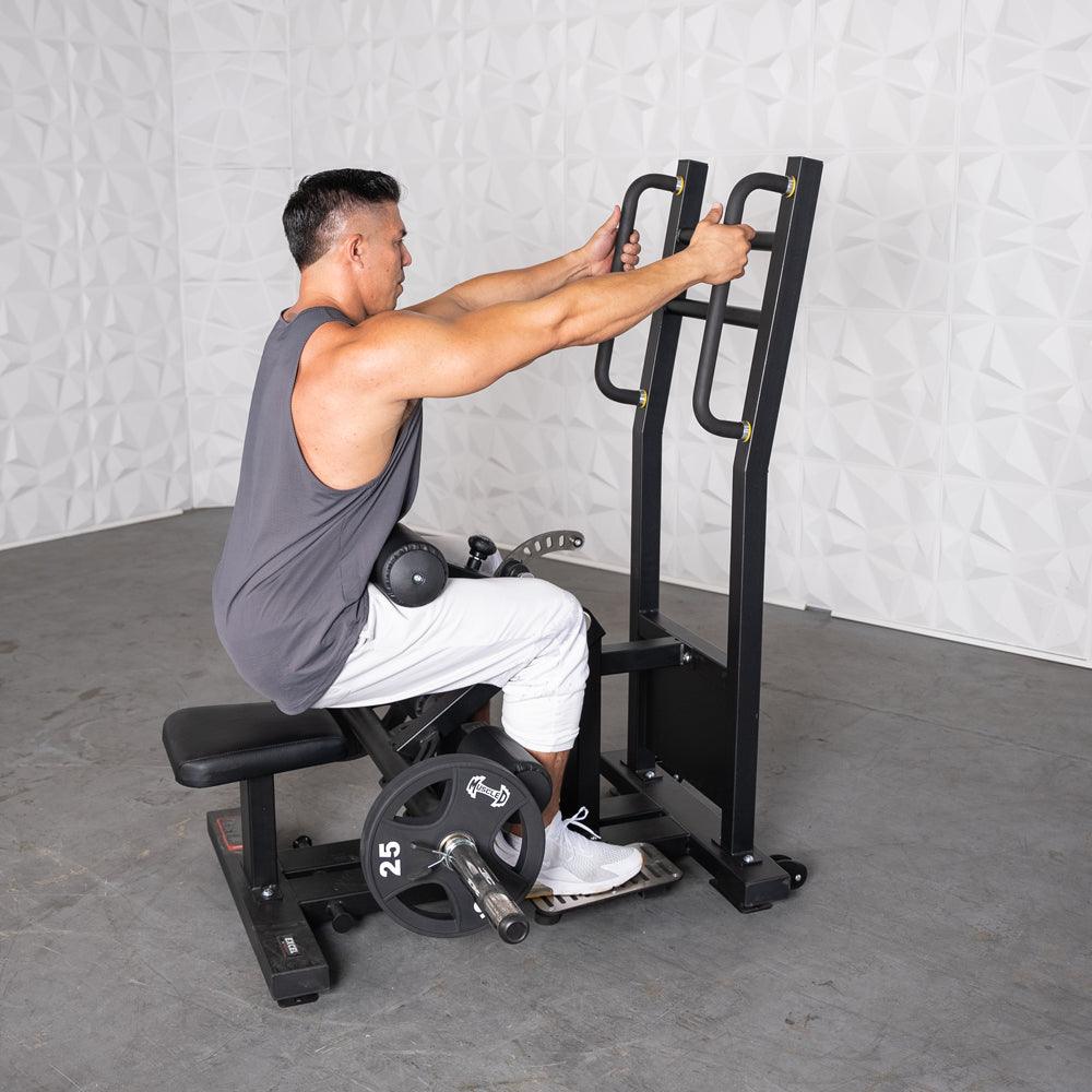 Man using a back extension machine with weights in a gym.
