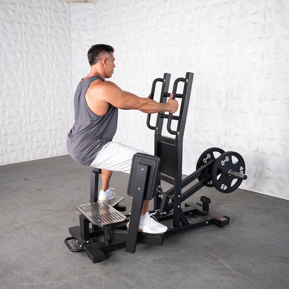 Man performing standing hip thrust on gym machine with weights.