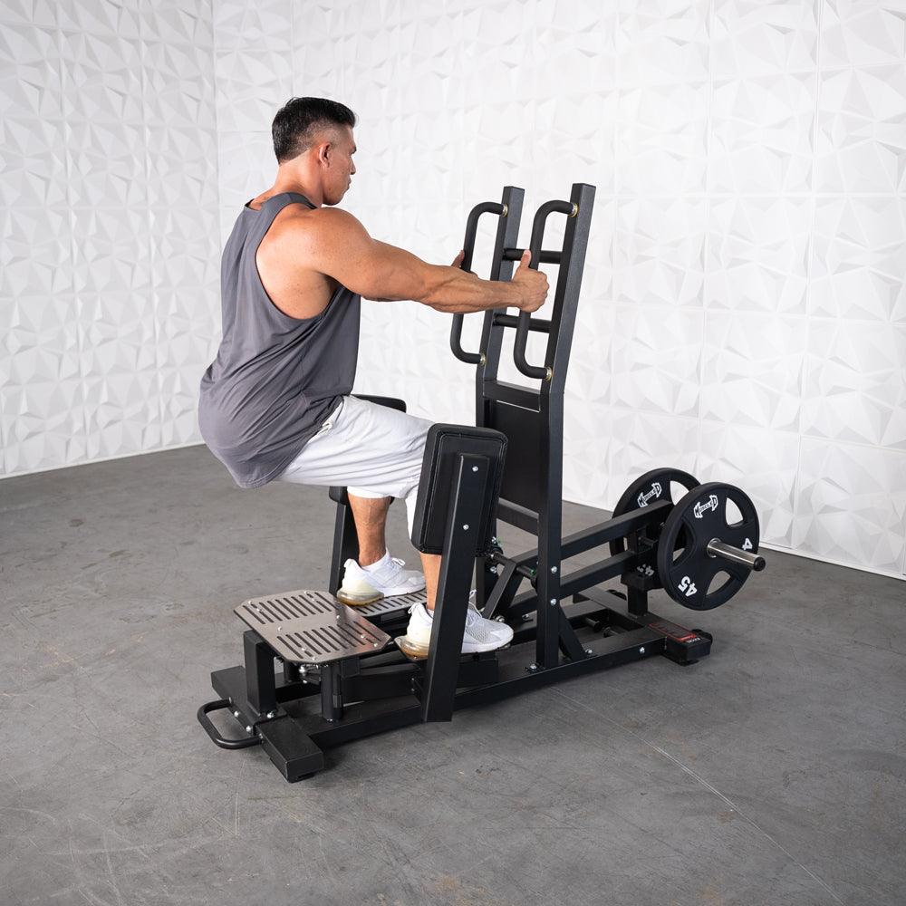 Man using a standing hip thrust machine with weight plates.
