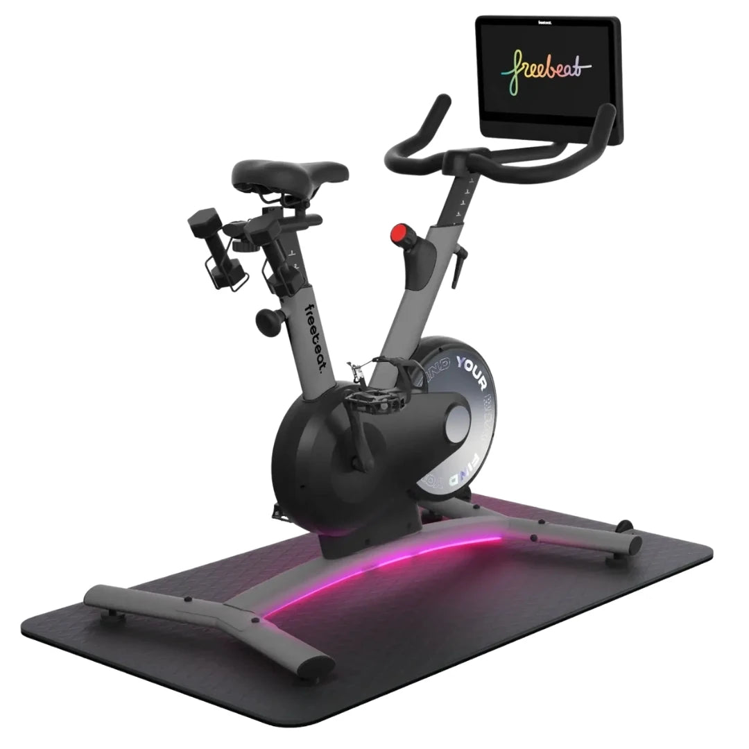 Freebeat Boom Stationary Exercise Bike with a digital display and adjustable handlebars, featuring a sleek design and illuminated base on a black mat.