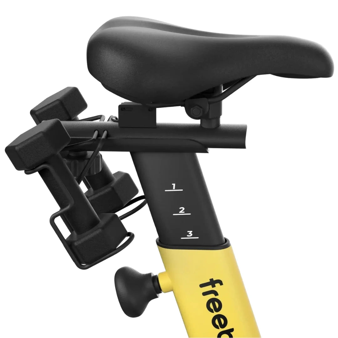 Close-up view of the seat and handlebars of the Freebeat Boom Stationary Exercise Bike, featuring numbered adjustment settings and attached weights.