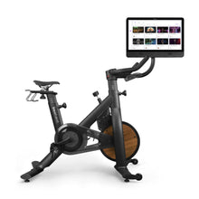 Tonal exercise bike with wood accents and interactive screen for home workouts.