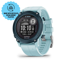 Garmin Descent G1 Solar - Ocean Edition smartwatch with a light blue strap, featuring a digital display showing time and dive data, and a label indicating it is made with recycled ocean-bound plastics.