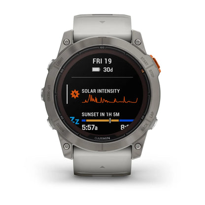 Garmin Fenix 7X Pro Sapphire Solar Edition smartwatch displaying solar intensity and sunset information on its screen.