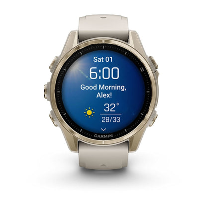 Garmin Fenix 8 AMOLED Edition smartwatch displaying the time 6:00, a greeting 'Good Morning, Alex!', and a weather forecast showing 32 degrees with a high of 33 degrees.