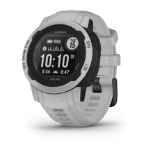 Garmin Instinct 2S Solar smartwatch displayed at an angle, featuring a round black face with white accents, showing the time and various metrics on the screen.