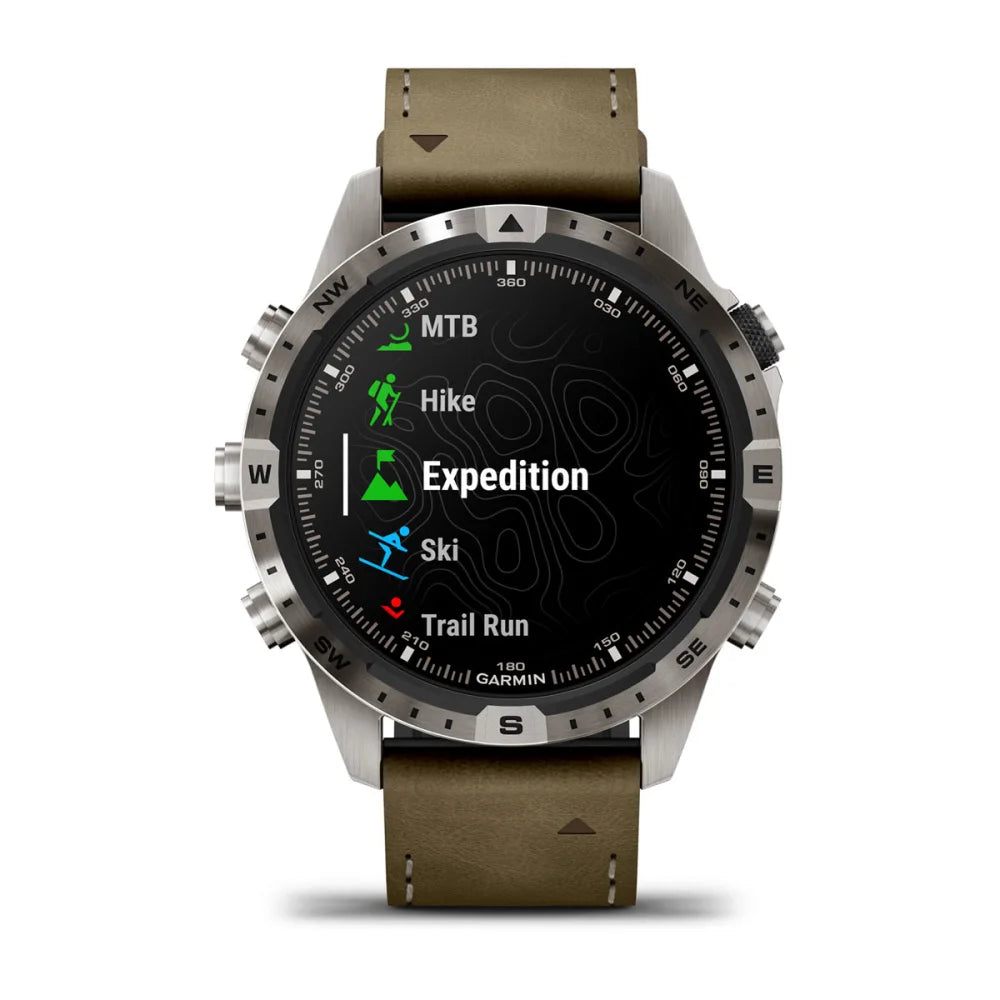 Garmin MARQ Adventurer (Gen 2) smartwatch displaying activity options including MTB, Hike, Expedition, Ski, and Trail Run on a dark screen with a metallic bezel and brown leather strap.