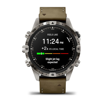 Garmin MARQ Adventurer (Gen 2) smartwatch displaying the time 11:24 PM, indicating a +2 hour difference vs local time and a message about slight jet lag expected.