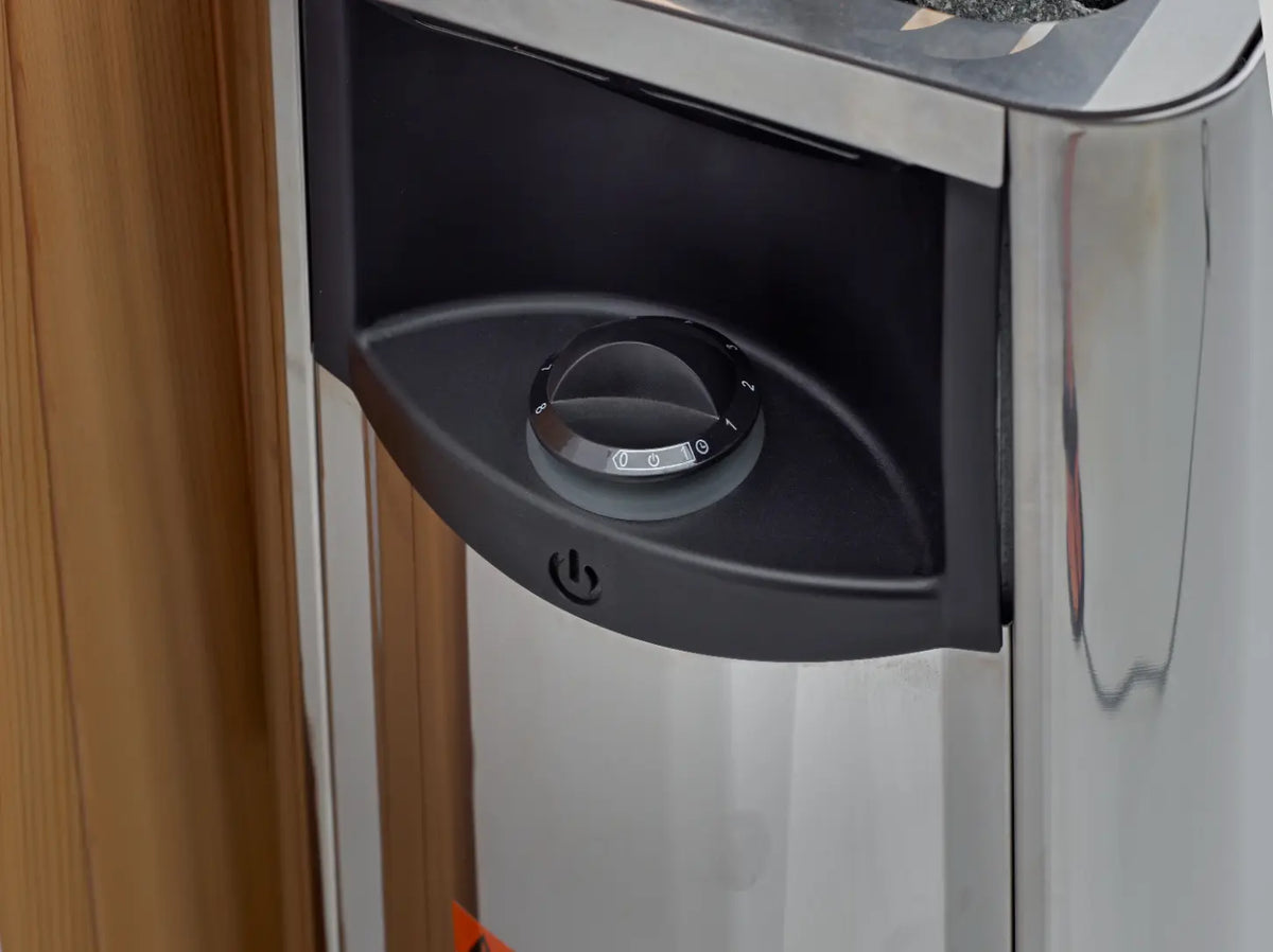 Close-up of a round sauna temperature control dial with a power button.