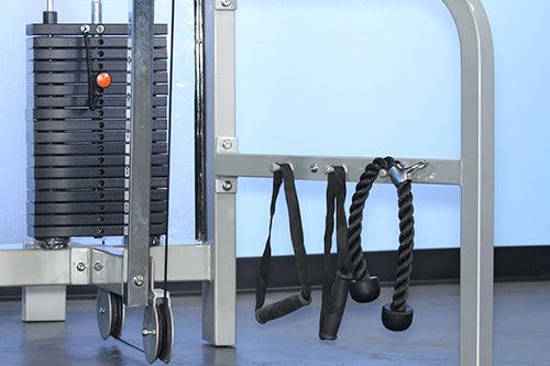 Gym weight stack pulley machine with rope handles on the floor.