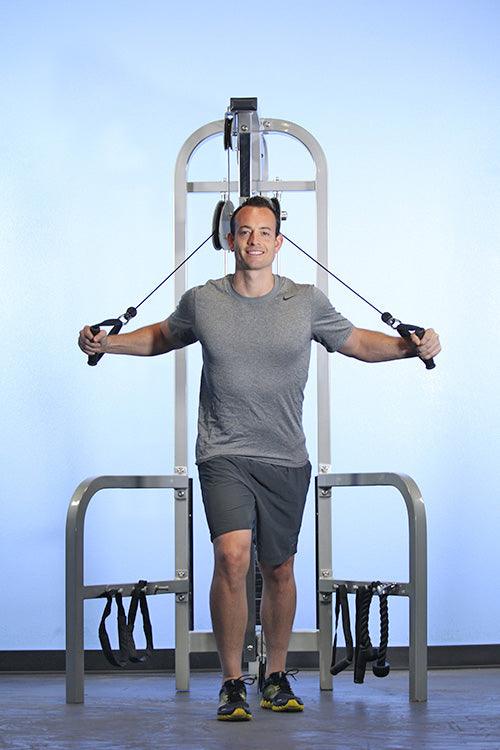 Man using a high-low pulley combo machine at the gym.