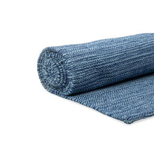 Rolled blue woven rug with a textured pattern.