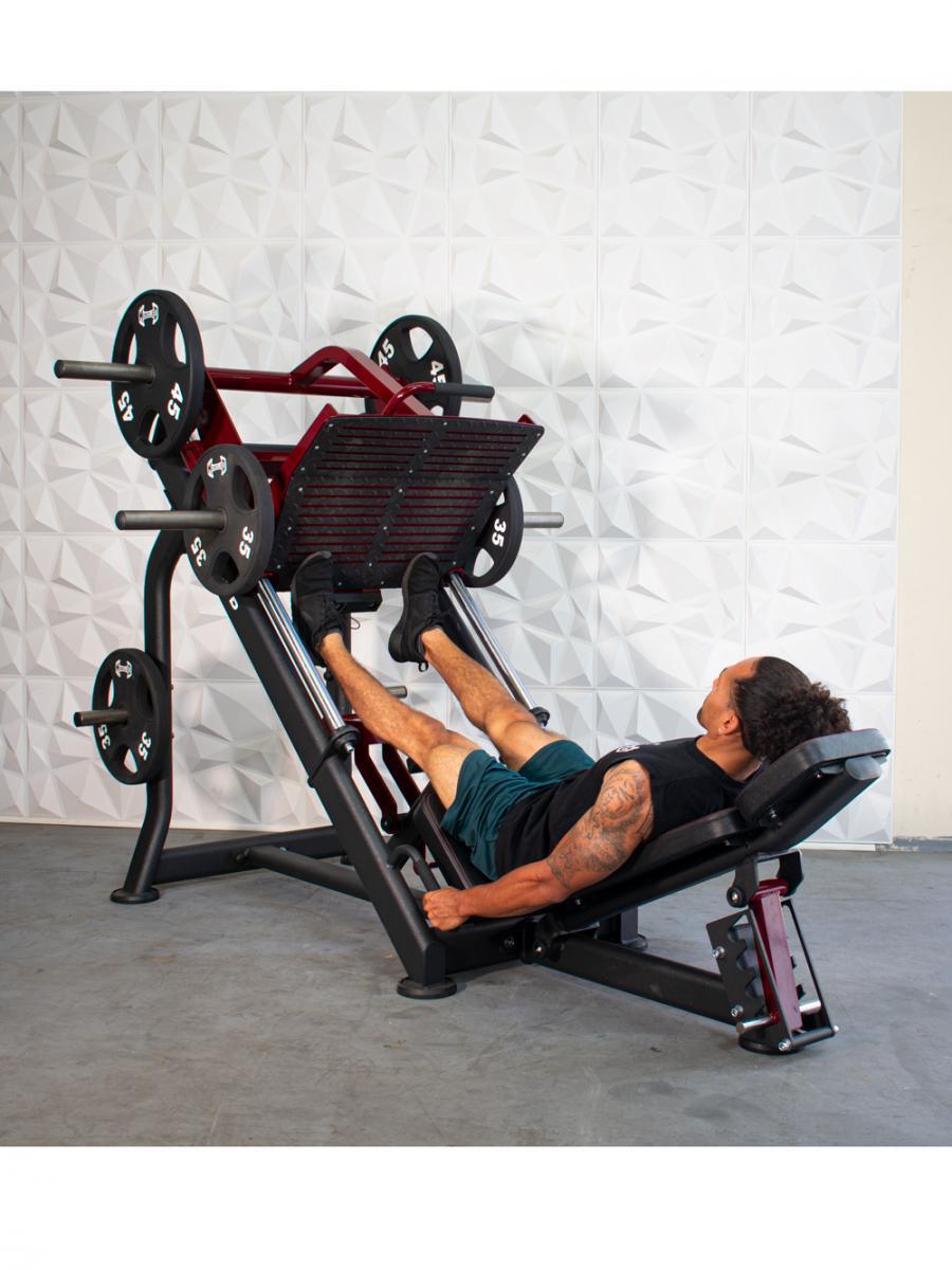 Man using a leg press machine in a gym.