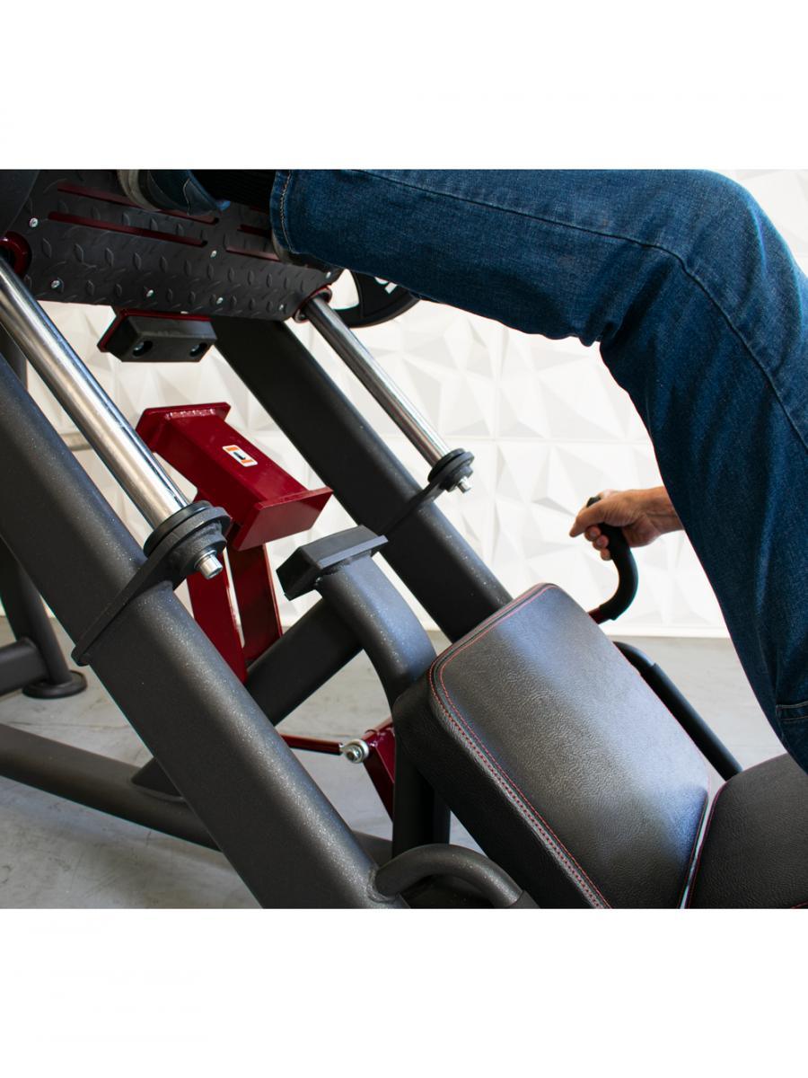 Person using a leg press machine with a padded leg pad and metal frame.