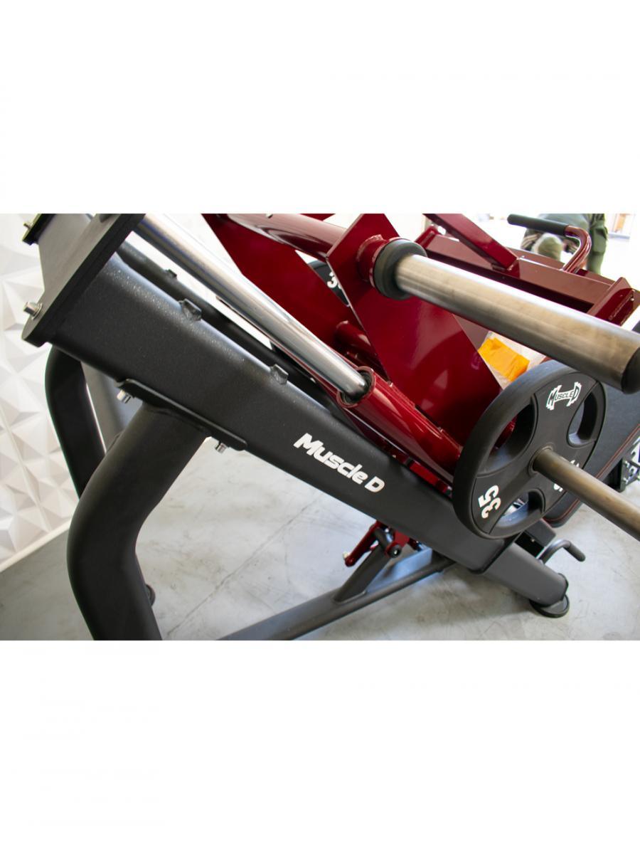 Leg press machine with black frame, silver rails, and weight plates.