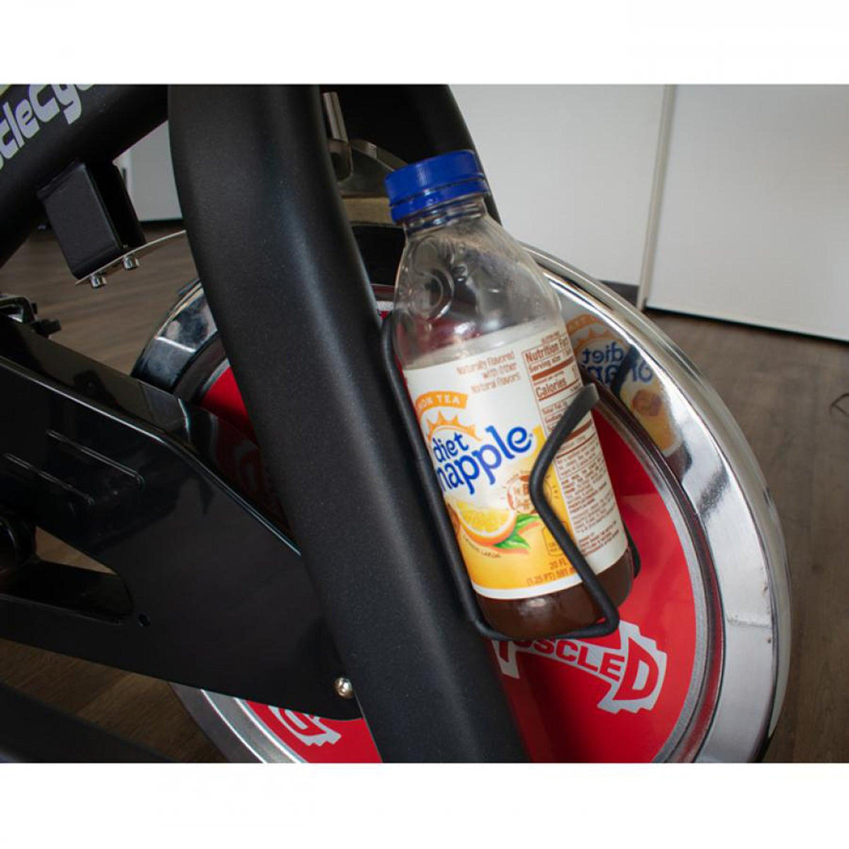 Diet Snapple bottle in a holder attached to a spin bike frame.