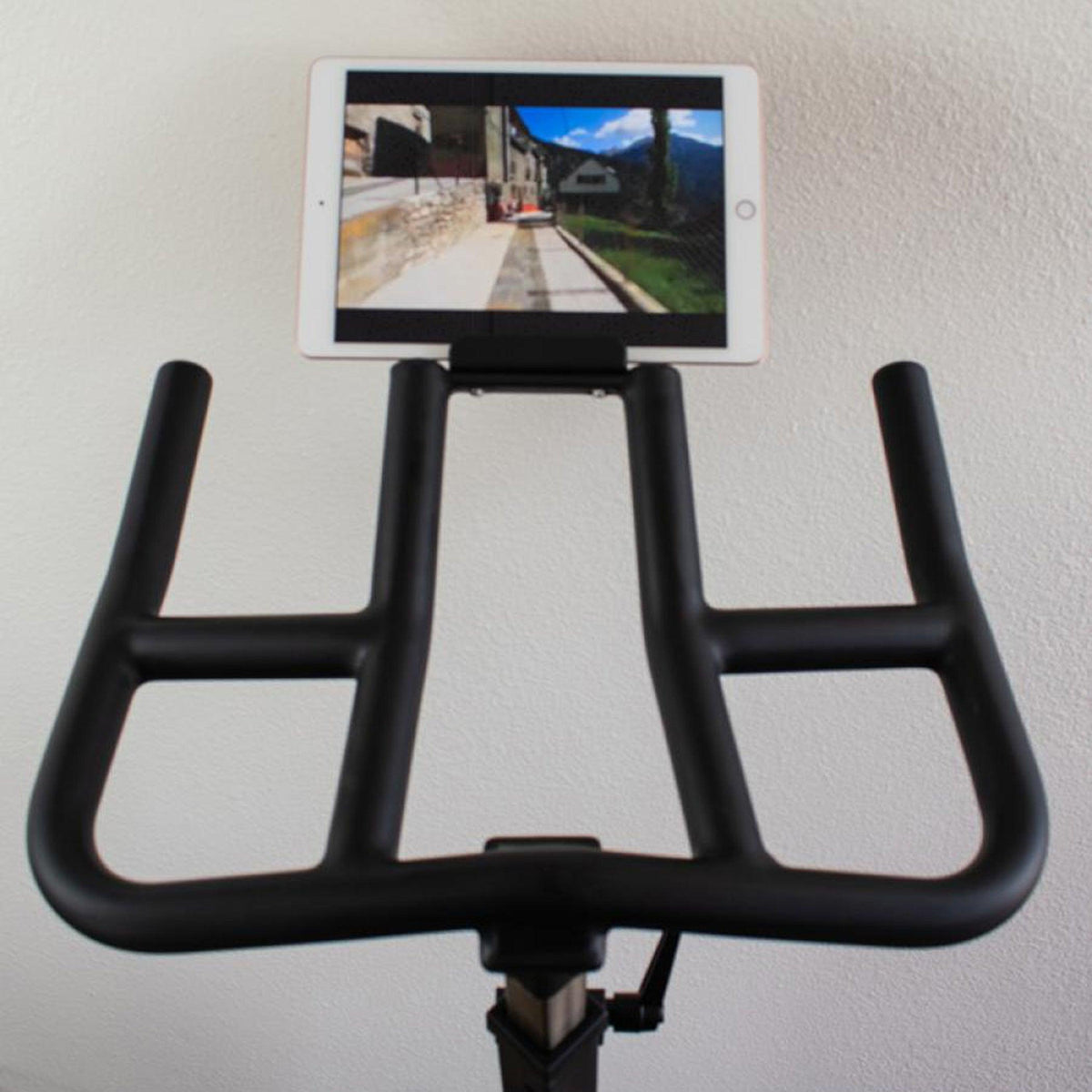 Light commercial spin bike with tablet mounted on the handlebar