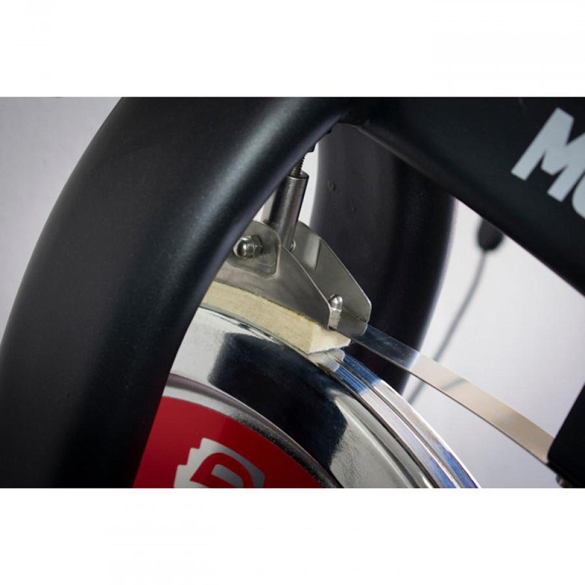 Close-up of a spin bike's flywheel area with an adjustment bracket.