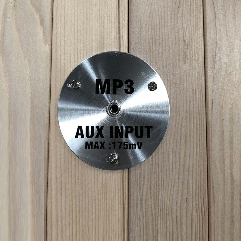 A close-up of an AUX input panel with the text 'MP3 AUX INPUT MAX: 175mV' displayed, part of the Maxxus Aspen Dual Tech 2 Person Far Infrared Sauna.