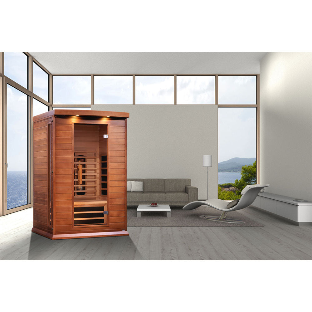 Maxxus 2 Person Full Spectrum Infrared Sauna displayed in a modern living room with large windows and a scenic view.