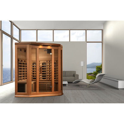 Maxxus 3 Person Full Spectrum Infrared Corner Sauna displayed in a modern living room with large windows and a view of the ocean.